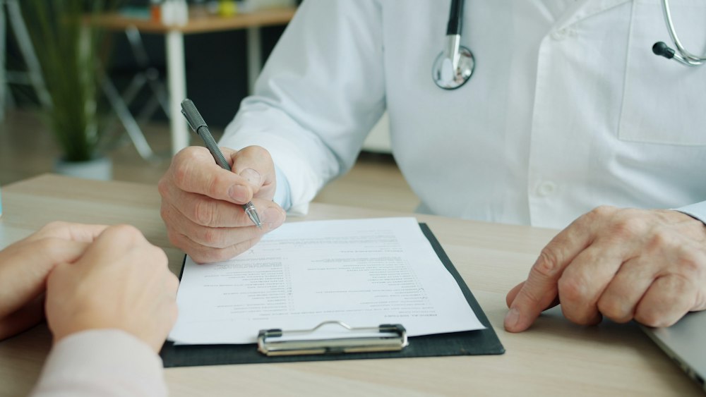 Médico diligenciando la historia clínica de un paciente